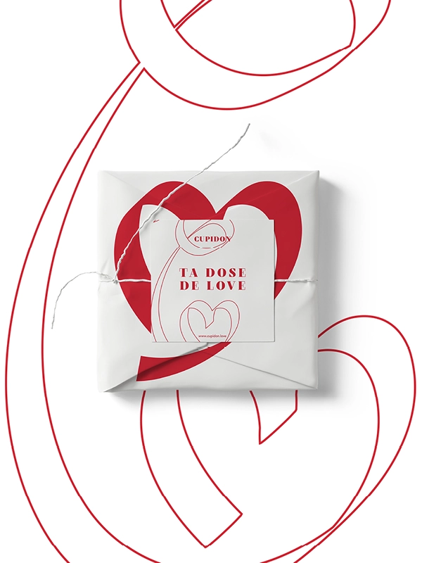 Packaging Cupidon – déclinaison identité visuelle sur boîte cadeau blanche avec motif cœur rouge et message Ta dose de love