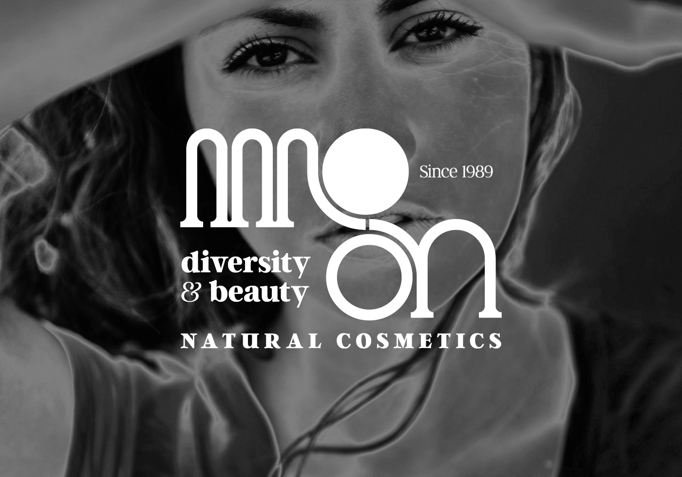 Logo Moon Natural Cosmetics – identité visuelle pour une marque de cosmétiques naturels avec un monogramme géométrique blanc sur une image en noir et blanc